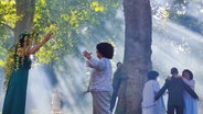 Menschen stehen auf einer Waldlichtung, einer umarmt einen Baum. © NDR / Svenja Estner Foto: Svenja Estner