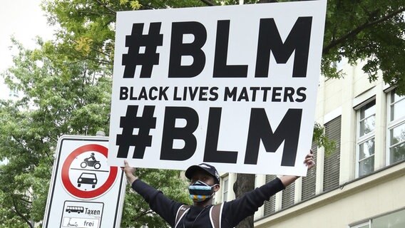 Eine Person hält auf einer Demonstration ein Plakat mit Aufschrift "#BLM Black Lives Matter" hoch. © picture alliance Foto: Christopher Tamcke / Geisler Fotopres