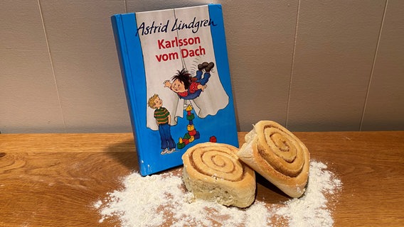 Vor dem Buch "Karlsson vom Dach" von Astrid Lindgren liegt Gebäck. © NDR Foto: Katharina Mahrenholtz