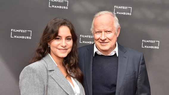 Eine junge Frau mit langen Haaren und ein älterer Mann stehen auf dem roten Teppich vom Filmfest Hamburg (Almila Bagriacik und Axel Milberg) © FIlmfest Hamburg / Martin Kunze Foto: Martin Kunze