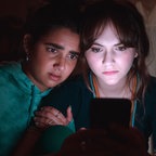 Zwei junge Frauen starren voller Angst auf einen Smartphone-Bildschirm - Geraldine Viswanathan und Emilia Jones in "Cat Person" © Studio Canal GmbH 