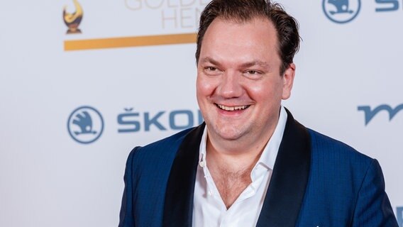 Der Schauspieler Charly Huebner, vor einer weißen Wand bei der MDR-Verleihung des Publikumspreises "Goldene Henne" im Oktober 2020 in Leipzig. © picture alliance / zb Foto: Kirsten Nijhof