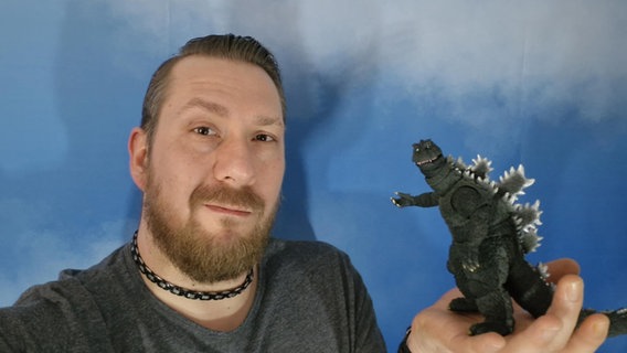 Michael Gofskie hält eine Godzilla-Figur in der Hand. © Michael Gofskie 