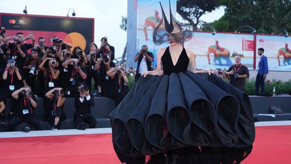 Lady Gaga in spektakulärem voluminösem Kostüm in Schwarz bei der Filmpremiere von "Joker - Folie à deux" in Venedig, die Fotografen machen am roten Teppich Fotos ©  Gian Mattia D'alberto/LaPresse via ZUMA Press/dpa Foto:  Gian Mattia D'alberto