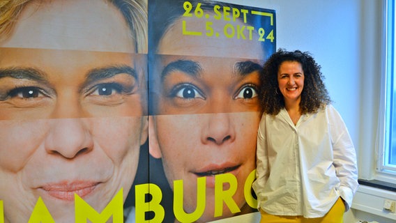 Die lächelnde Festivalchefin Malika Rabahallah vor einem Plakat des Filmfests Hamburg © NDR Foto: Britta Schmeis