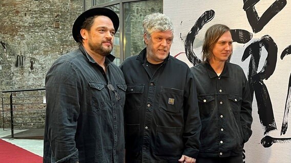 Drei Männer stehen vor einem Kinoplakat - Ronald Zehrfeld (von links), Matthias Glasner und Lars Eidinger bei einer Kinopremiere von "Sterben" im Zeise Kino Hamburg © NDR Foto: Patricia Batlle