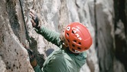 Ein Bergsteiger klettert an einer Felswand © NDR Screenshot 