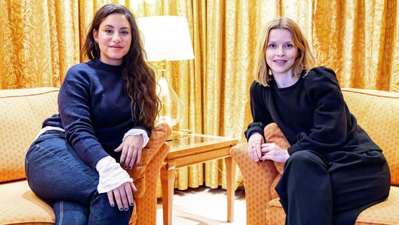 Zwei junge Frauen mit je dunklen und hellen Haaren sitzen in zwei Sessel in einem Hotel © Axel Heimken/dpa +++ dpa-Bildfunk ++ Foto: Axel Heimken