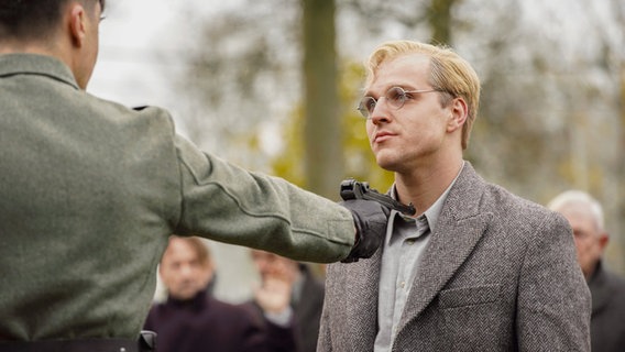 Ein Mann wird von einem Beamten mit einer Waffe bedroht © Kinostar Filmverleih GmbH 