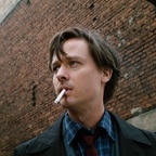 Fabian (Tom Schilling) stands in front of a factory smoking.  © Lupa Film / Hanno Lentz / DCM 