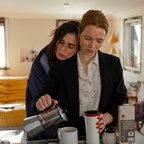 Die Schauspielerin Karolin Herfurth schenkt Kaffee in eine Tasse, während sich die Schauspielerin Nora Tschirner an sie lehnt. © 2024 Hellinger / Doll Filmproduktion GmbH / Warner Bros. Entertainment GmbH Foto:  Anne Wilk