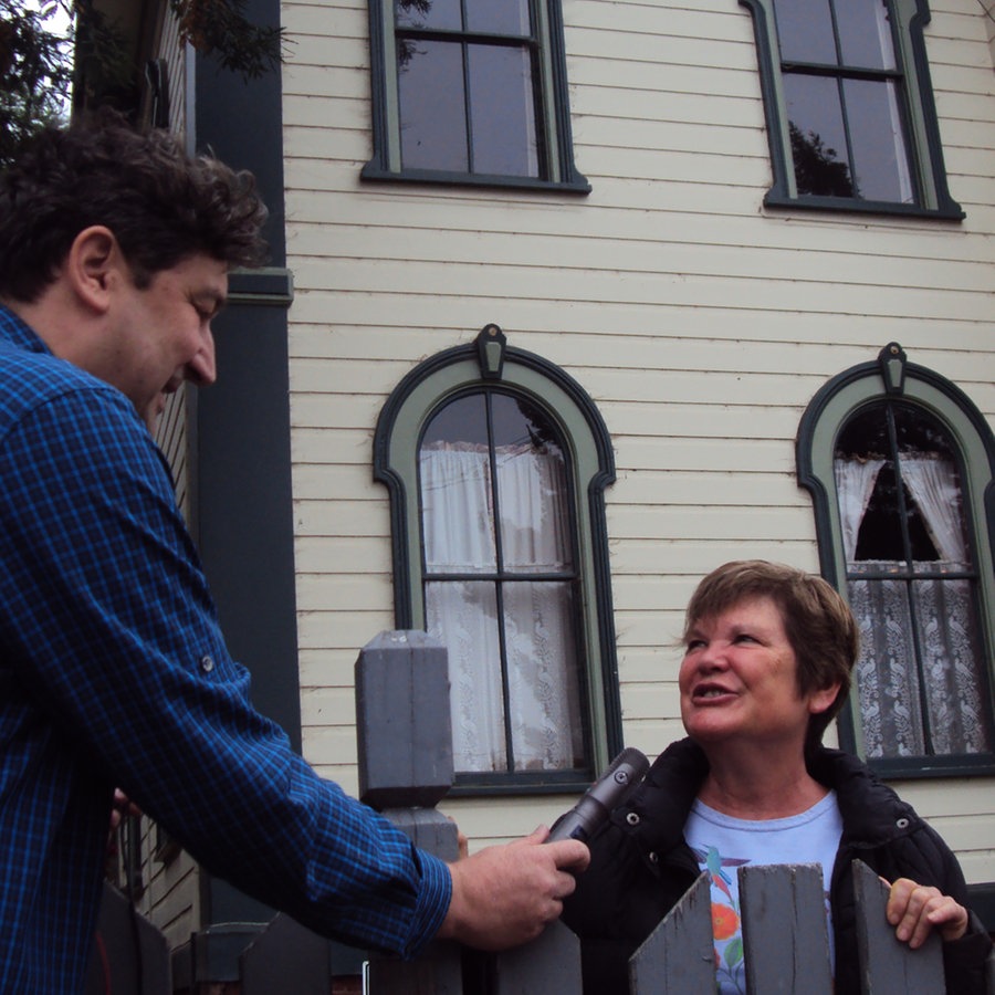 Ein Mann mit Mikrofon interviewt eine Frau vor einem Haus, das für einen Dreh eines Hitchcockfilms in Kalifornien genutzt wurde © NDR Foto: Guido Meyer / Peter Kuttler