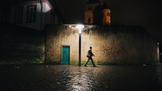 Eine Person läuft durch eine dunkle Straße, die nur von einer Laterne beleuchtet wird. © photocase/Jens Lumm Foto: Jens Lumm