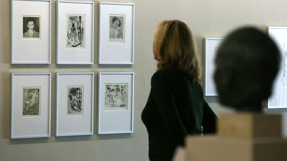 Eine Frau schaut sich in der Kunsthalle in Rostock Grafiken von Inge Jastram an. © picture alliance / ZB Foto: Bernd Wüstneck