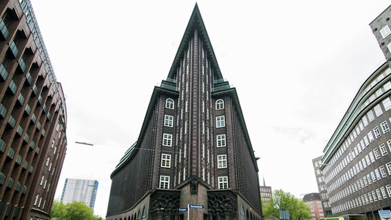 Frontaler Blick auf ein spitz zulaufendes Backstein-Gebäude (das Chilehaus in Hamburg). © picture alliance / dpa Foto: Daniel Bockwoldt