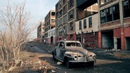 Ein Autowrack auf einem brach liegenden Fabrikgelände in Detroit. © Archäologisches Museum Hamburg Harburg 