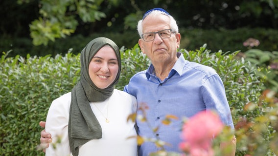 Eine junge Frau mit Kopftuch und ein älterer Mann mit Kippa posieren vor der Kamera © Region Hannover/Ines Schiermann Foto: Ines Schiermann