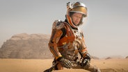 Der Schauspieler Matt Damon in einem Astronautenoutfit in dem Film "Der Marsianer" © dpa/Twentieth Century Fox 