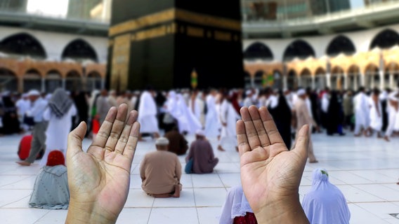 Menschen beten vor der Al-Haram-Moschee in Mekka © imago 