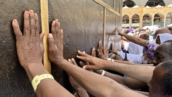 Hände berühren die Kaaba in Mekka © picture alliance / Anadolu | Turkiye Directorate Of Religious Affairs Foto: Cem Iskender Ozbali