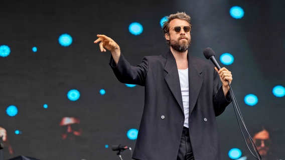 Ein Mann mit sonnenbrille, Bart und Sakko singt auf der Bühne - Father John Misty © Daniel DeSlover/ZUMA Press Wire Foto: Daniel DeSlover