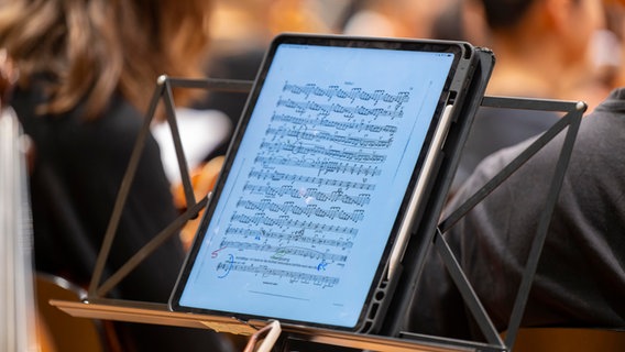 Noten mit einer Partitur auf einem iPad stehen auf einem Notenständer während eines Konzertes. © picture alliance / M.i.S. | Bernd Feil Foto: Bernd Feil