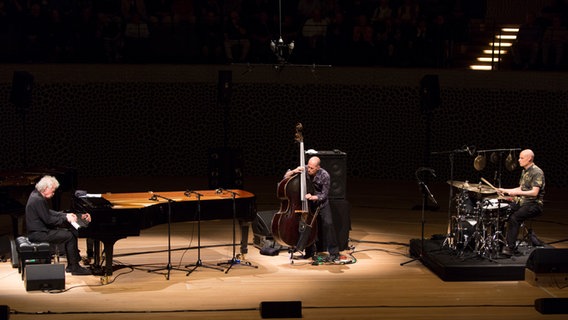 Drei Männer mit Musikinstrumenten musizieren auf einer Bühne © Mücke Quinckhardt Foto: Mücke Quinckhardt