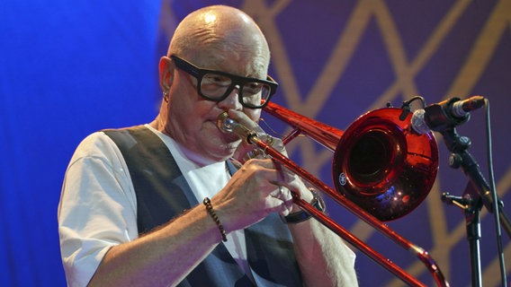 Ein Mann mit einer schwarzen Brille spielt Posaune. © picture alliance / Lutz Knauth Foto: Lutz Knauth