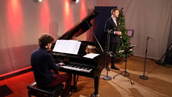 Ein Mann mit braunen Locken sitzt am schwarzen Flügel und dahinter steht ein Sänger am Mikrofon. © Ekaterina Shurygina / NDR Foto: Ekaterina Shurygina / NDR