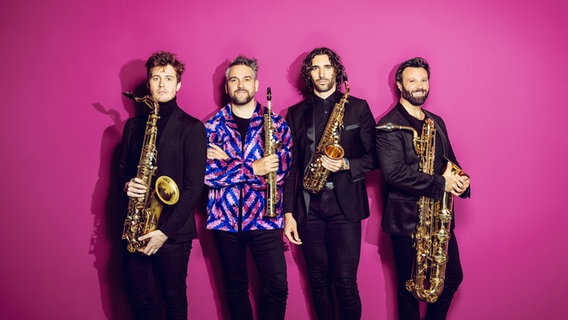 Vier Personen mit Saxofonen vor einem pinkfarbenen Hintergrund © Nikolaj Lund / Festspiele MV 