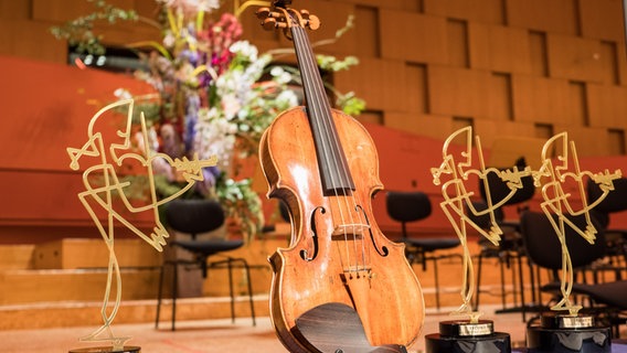 Eine Geige neben der Trophäe des Joseph Joachim Violinwettbewerbs © Stiftung Niedersachsen Foto: Helge Krückeberg