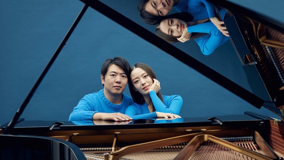 Der chinesische Pianist Lang Lang und seine Frau, die Pianistin, Gina Alice Redlinger, sitzen an einem schwarzen Flügel. © Olaf Heine 