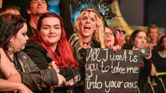 Fans mit einem Plakat vor einer Bühne beim M'era Luna 2023 © NDR Foto: Benjamin Hüllenkremper