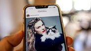 Auf dem Display eines Handys ist ein Post von Taylor Swift zu sehen, die eine Katze im Arm hält © picture alliance / abaca | Foto: Balkis Press/ABACA