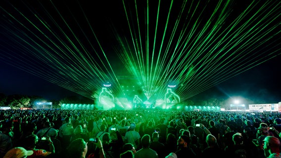 Eine Lasershow mit grünen Lichtern vor einem großen Festivalpublikum. © Deichbrand Festival Foto: Robin Schmiedebach