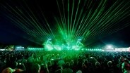 Eine Lasershow mit grünen Lichtern vor einem großen Festivalpublikum. © Deichbrand Festival Foto: Robin Schmiedebach