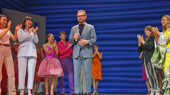 Ein Mann mit dunklen Haaren und dunkler Brille steht auf der Bühne in London von "Mamma Mia",  Björn Ulvaus, schwedischer Musiker mit Darstellern des Musicals "Mamma Mia" © Lucy North/PA Wire Foto: Lucy North