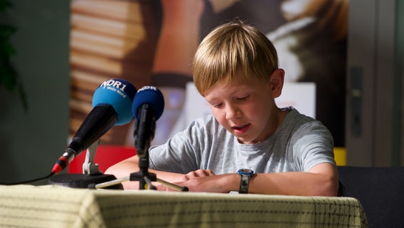 Ein Schüler liest eine Geschichte auf der Bühne vor © NDR Foto: Lornz Lorenzen