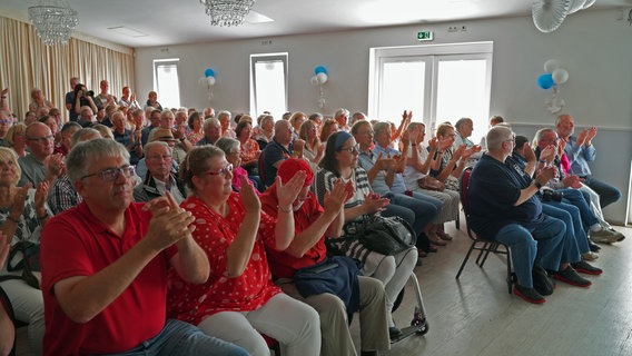 Viele Menschen im Saal klatschen und spenden der Band Godewind Applaus. © Lornz Lorenzen Foto: Lornz Lorenzen