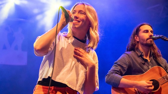 Die Musikerin Norma steht auf einer Bühne, neben ihr ein Gitarrist ihrer Band. © Sebastian Schollmeyer 