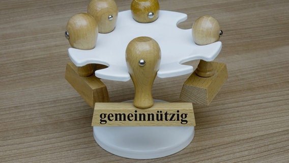 An einem Stempelhalter hängt ein Stempel mit dem Schriftzug "gemeinnützig". © picture alliance / ZB | Sascha Steinach 