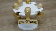 An einem Stempelhalter hängt ein Stempel mit dem Schriftzug "gemeinnützig". © picture alliance / ZB | Sascha Steinach 
