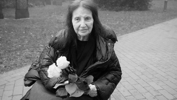 Peggy Parnass mit zwei weißen Tulpen in der Hand. © picture alliance/dpa | Georg Wendt 