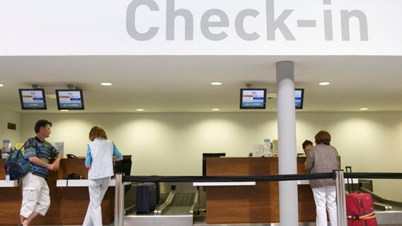 Fluggäste checken an einem Check-in-Schalter im Flughafen Bern-Belp ein. © Picture-Alliance/KEYSTONE Foto: Alessandro della Valle