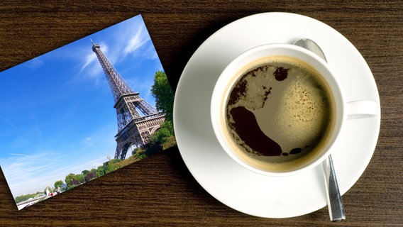 Collage: Eine Tasse Kaffee neben einer Postkarte mit dem Eiffelturm. © Kaffee: © M&M - Fotolia.com, Paris: © Ignatius Wooster - Fotolia.com Foto: Kaffee: © M&M - Fotolia.com, Paris: © Ignatius Wooster - Fotolia.com