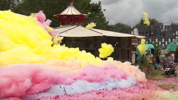 Ein bunter Schaumberg mit fliegenden Wölkchen - im Hintergrund ein Pavillon. © NDR 