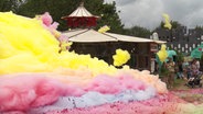 Ein bunter Schaumberg mit fliegenden Wölkchen - im Hintergrund ein Pavillon. © NDR 