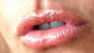 Mund einer jungen Frau mit aufgepritzten und geschminkten Lippen © McPHOTO 
