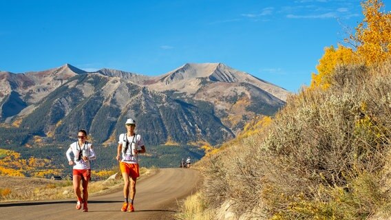 Zwei Personen joggen einen Weg entlang, im Hintergrund Berge und blauer Himmel © picture alliance / Newscom Foto: Larry Clouse/Csm