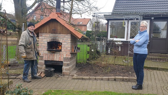 Für die Notfallübung "Backen ohne Strom"  haben die Nachbarn Dieter und Brigitte schon mal angeheizt. © NDR/Fritz Tietz Foto: Fritz Tietz